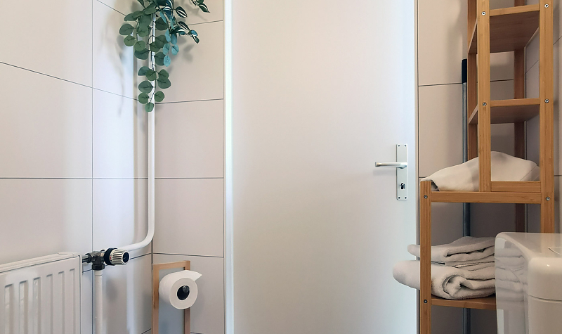 Modernes Bad mit Grünpflanzen und Regal