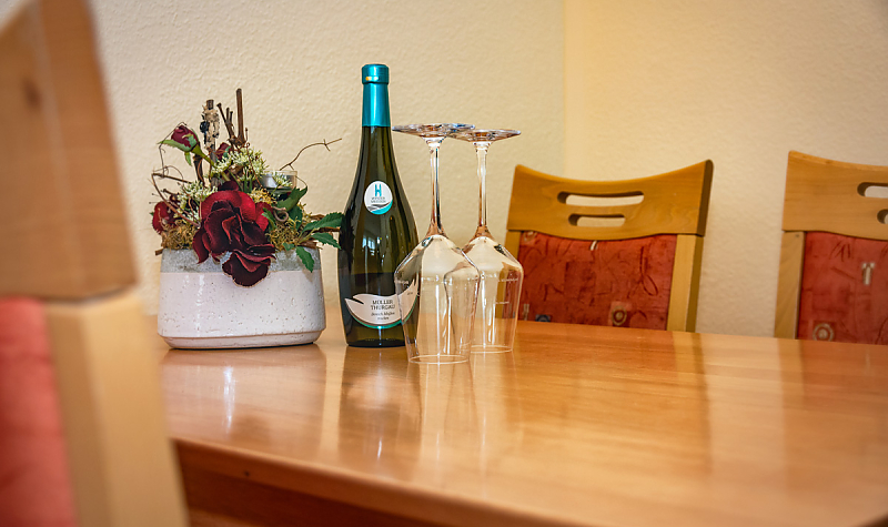 Gästewohnung Radebeuler Str. 6b - Tisch mit Weinflasche, Gläsern und Blumen