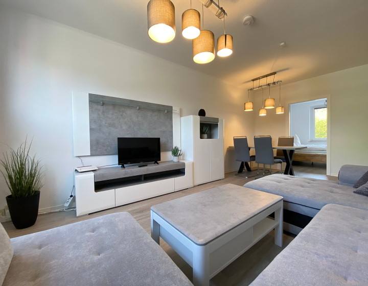 Gästewohnung mit Couchlandschaft und Medienwand sowie dezenter Beleuchtung